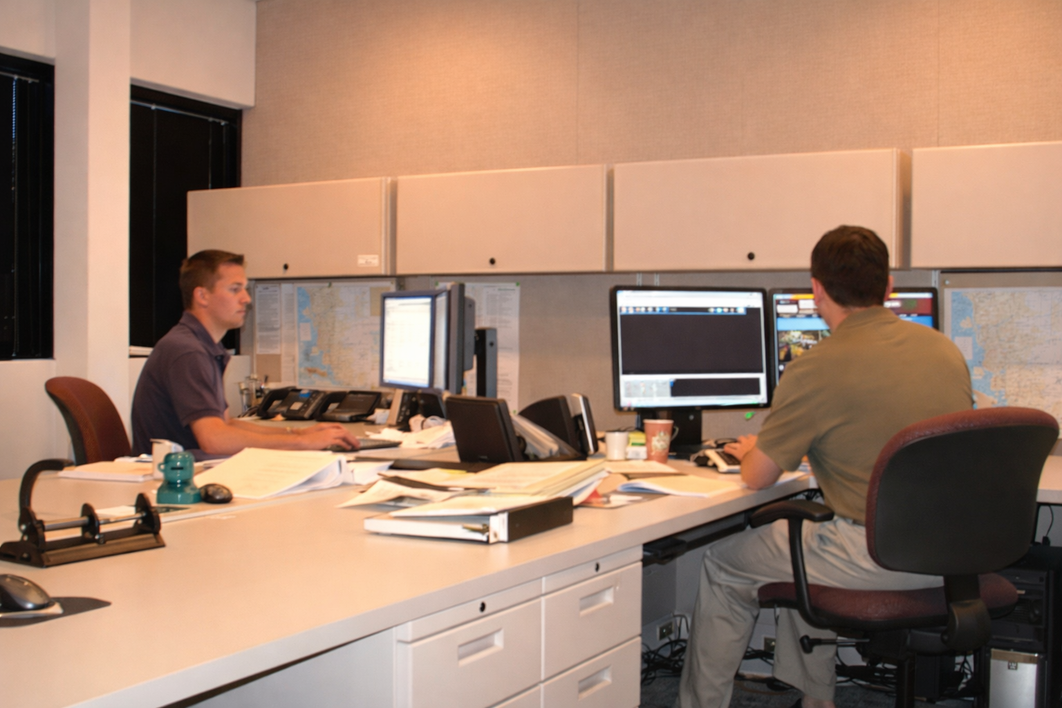 Power traders monitoring and managing energy transactions at computer workstations